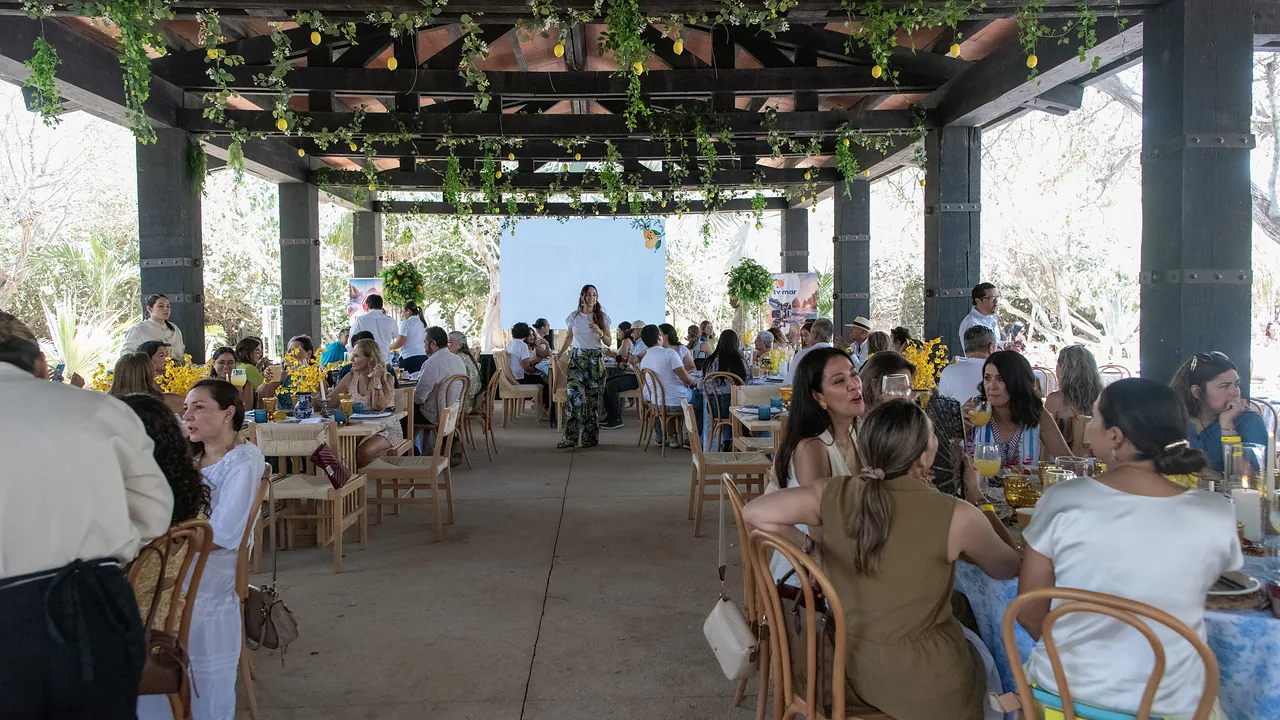 Guests share brunch under a vine-draped palapa at Brunch con Causa