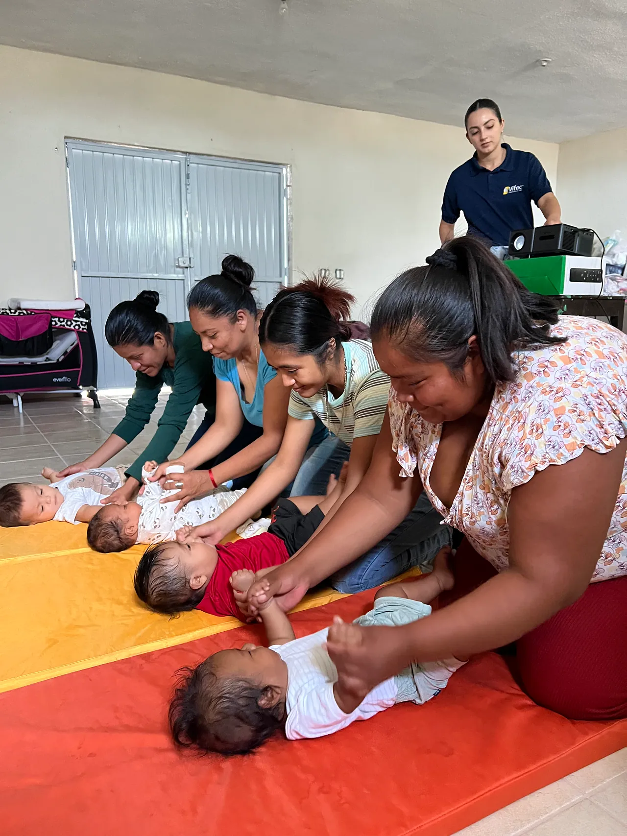 Mothers practice infant massage with their babies during an early-stimulation workshop