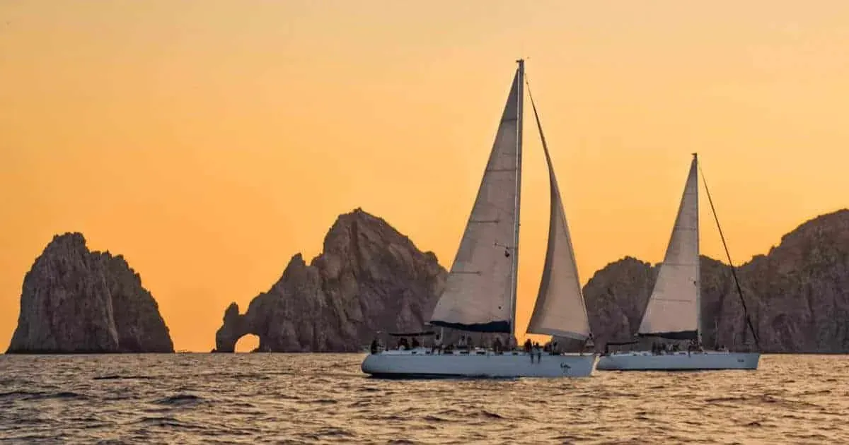 Un velero navega frente al Arco de Cabo San Lucas al atardecer