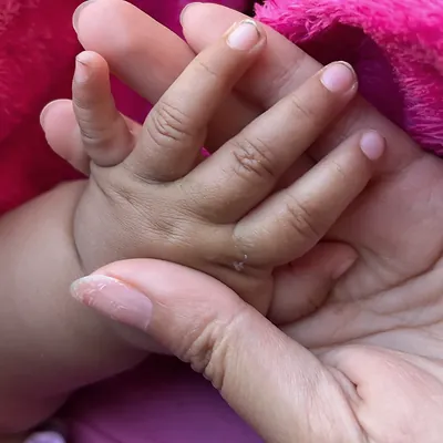 A baby's small hand resting in a woman's open palm