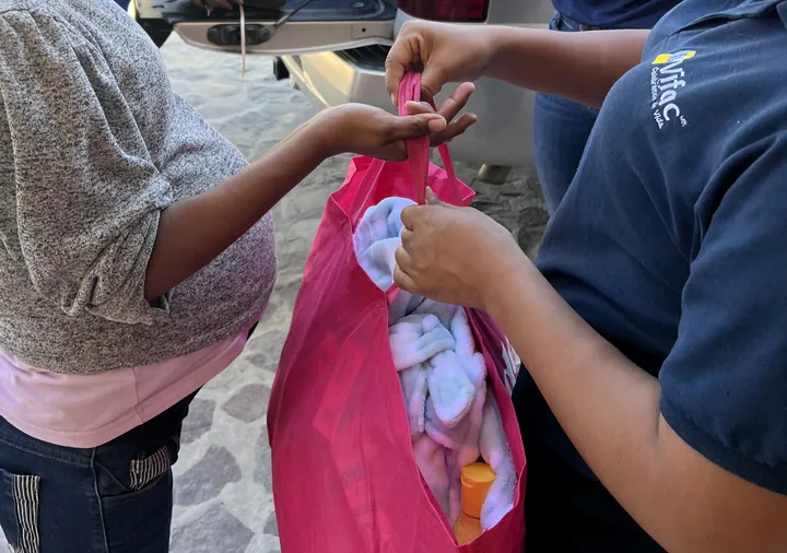 A VIFAC Los Cabos team member hands a support bag to a mom