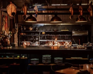 The open kitchen at Lumbre, with the fire lit under the hanging lamps