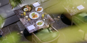 Overhead view of a courtyard breakfast spread on a marble table beside the banquette