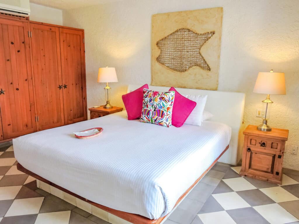 Casa Natalia Boutique Hotel — guestroom with a carved wooden armoire, fish artwork and a chequered floor