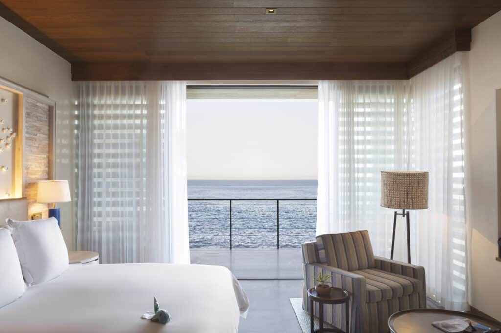 Chileno Bay guestroom with the bed facing an open terrace and the Sea of Cortez