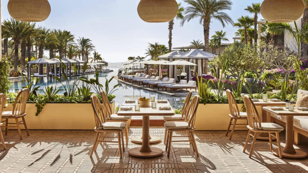 Chileno Bay Resort & Residences — restaurant terrace with dining tables and cabanas above the pool and the sea