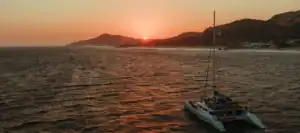 Aerial view of the EcoCat sunset cruise off the Cabo San Lucas coast at dusk