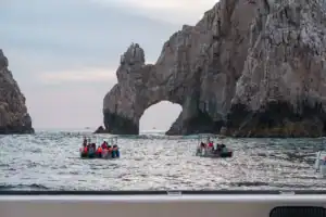 Cabo's Arch at dusk seen from the EcoCat deck with water taxis below