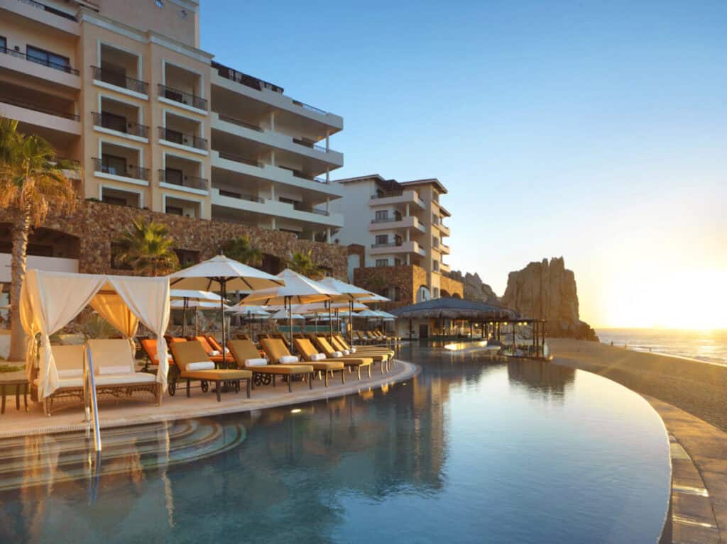 Grand Solmar Land’s End Resort & Spa — infinity pool with cabanas and loungers at sunrise, the rocks of Land’s End beyond