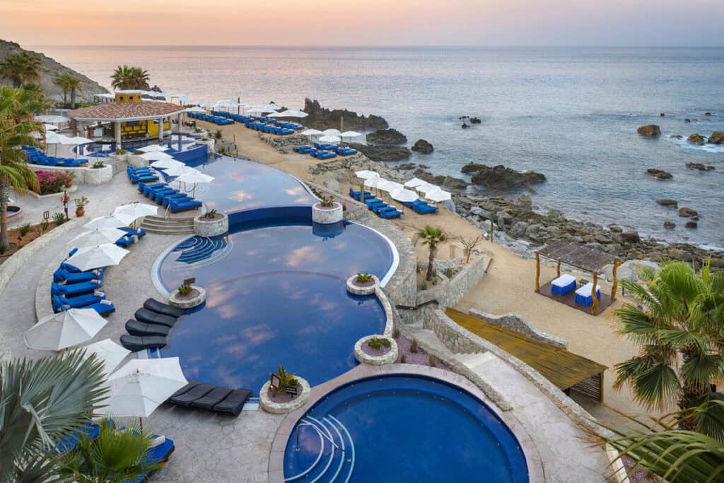 Hacienda Encantada Resort & Spa — terraced pools with blue loungers above the rocky shoreline