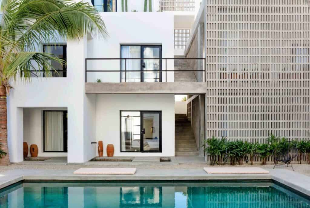 Drift San José del Cabo — white modernist building with a lattice screen above the pool