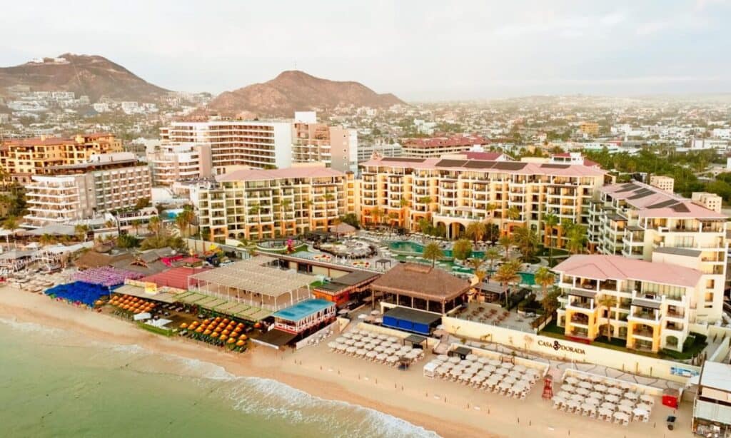 Casa Dorada Los Cabos Resort & Spa — aerial view over Médano Beach with the resort and its beach clubs