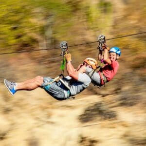 Father and son on a side-by-side zipline ride at Wild Canyon, Cabo
