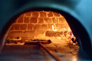 Wood-fired brick oven with pizzas baking at Bar Esquina, Cabo San Lucas