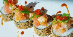 Seafood sushi rolls topped with salmon and tobiko