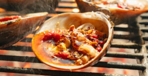 Grilled clams (almejas) sizzling over an open flame