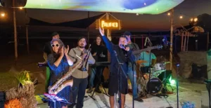 Live band performing at night under a palapa canopy