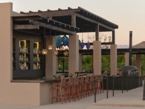The open bar and wood-fired oven at dusk under hanging star lanterns