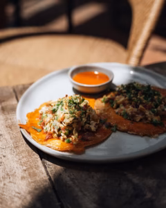 Breakfast tostadas with scrambled eggs, bacon, cilantro, and habanero salsa