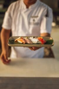 Chef holding a platter of omakase nigiri at El Puesto, Four Seasons Costa Palmas