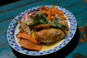 Roasted free-range chicken plated with carrots, sweet potato and pickled vegetables