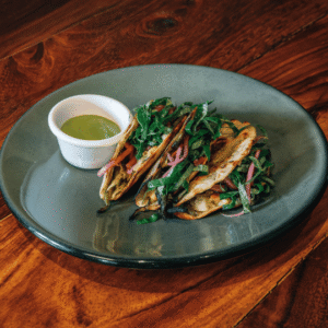 Tacos with greens and a side dipping sauce