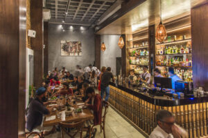 Interior dining room with the long, stocked bar and guests
