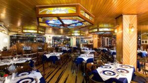 Lorenzillo's main dining room with nautical stained-glass lamps and wood ceilings in Cabo San Lucas