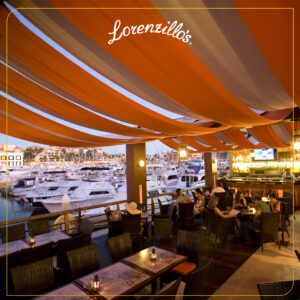 Lorenzillo's covered terrace lounge overlooking moored yachts on the Cabo San Lucas marina at dusk