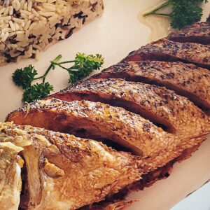 Grilled whole fish sliced and plated with wild rice at Lorenzillo's Cabo San Lucas