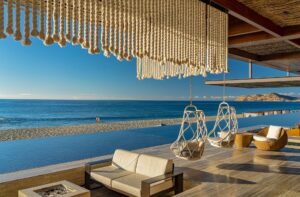Mako lounge with woven hanging chairs, sofas and a firepit by the infinity pool, Solaz a Luxury Collection Resort