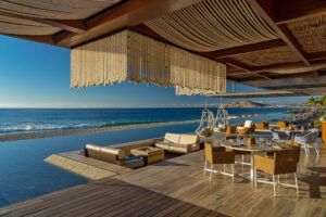 Mako deck with a beaded rope chandelier along the infinity-pool edge at golden hour, Solaz a Luxury Collection Resort