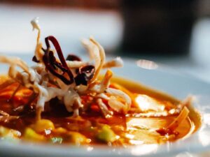 Tortilla soup garnished with crisp tortilla strips and dried chile