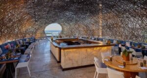 Interior dining room and onyx-lit sushi counter beneath the NIDO nest-dome with central oculus