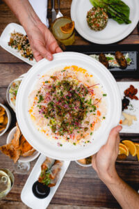 Scallop carpaccio (carpaccio de callo) served on a shared wood table
