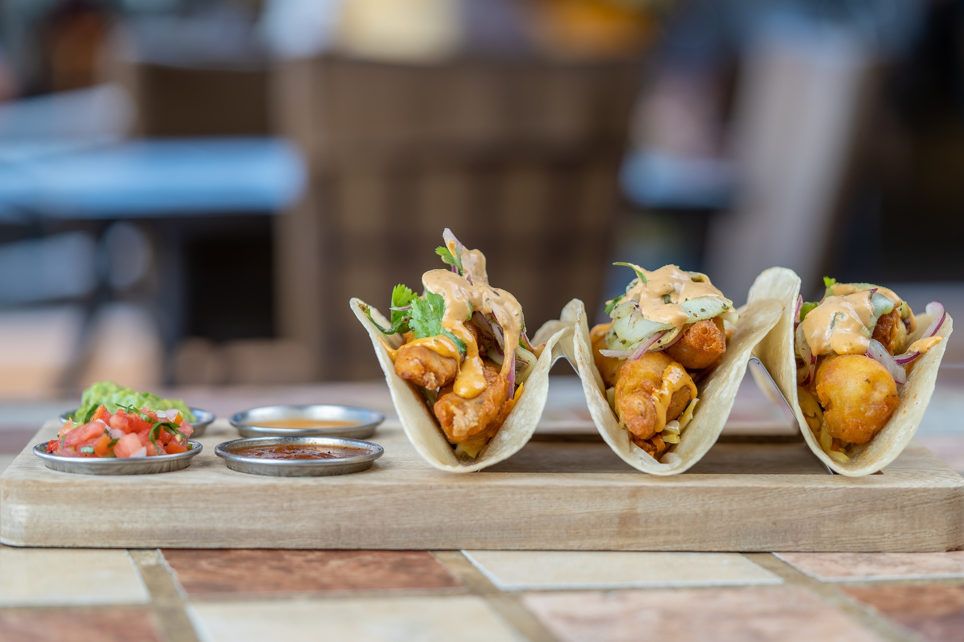 Baja fish tacos on a wooden board with salsas at Solomon's Landing Cabo San Lucas