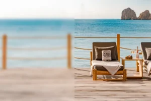 Wooden beach deck with sun loungers, towels and a Champagne setup framing the Arch