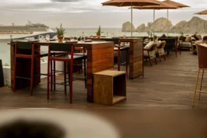 Set terrace high-top tables with umbrellas overlooking the bay and Land's End