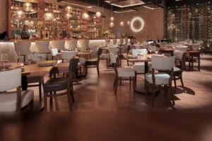 Polished indoor dining room with a back-lit bar, ring chandelier and set tables
