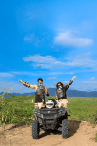 Two Cabo Adventures guests in protective gear posing with an ATV