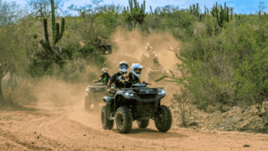 Small guided group riding ATVs through Baja desert vegetation at Tierra Sagrada