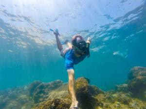 Snorkeler swimming above a rocky reef on a Cabo Trek tour