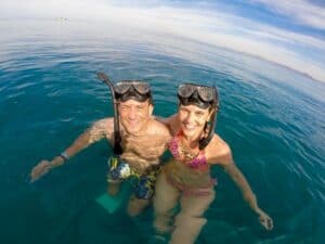 Couple wearing masks and snorkels in calm Cabo water