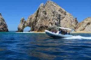Snorkelers following a Cabo Expeditions guide near a rocky bay