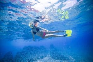 Guest using mask and snorkel during a guided Cabo beach stop