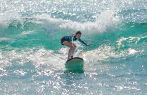 Participant balancing on a wave during the Costa Azul group lesson