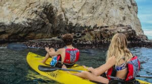 High Tide guests paddling a glass-bottom kayak along the Land's End coastline