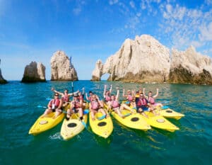 Group of High Tide kayakers gathered in front of Land's End rock formations