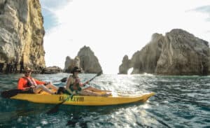 Couple kayaking on the Sea of Cortez with the Arch behind them
