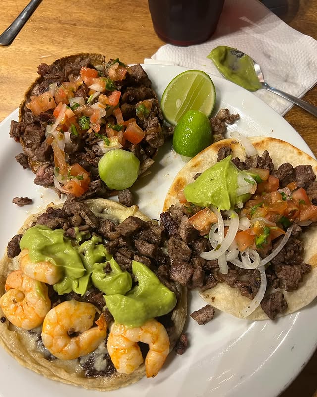 Plate of beef and shrimp tacos topped with guacamole and lime at a San José del Cabo taqueria